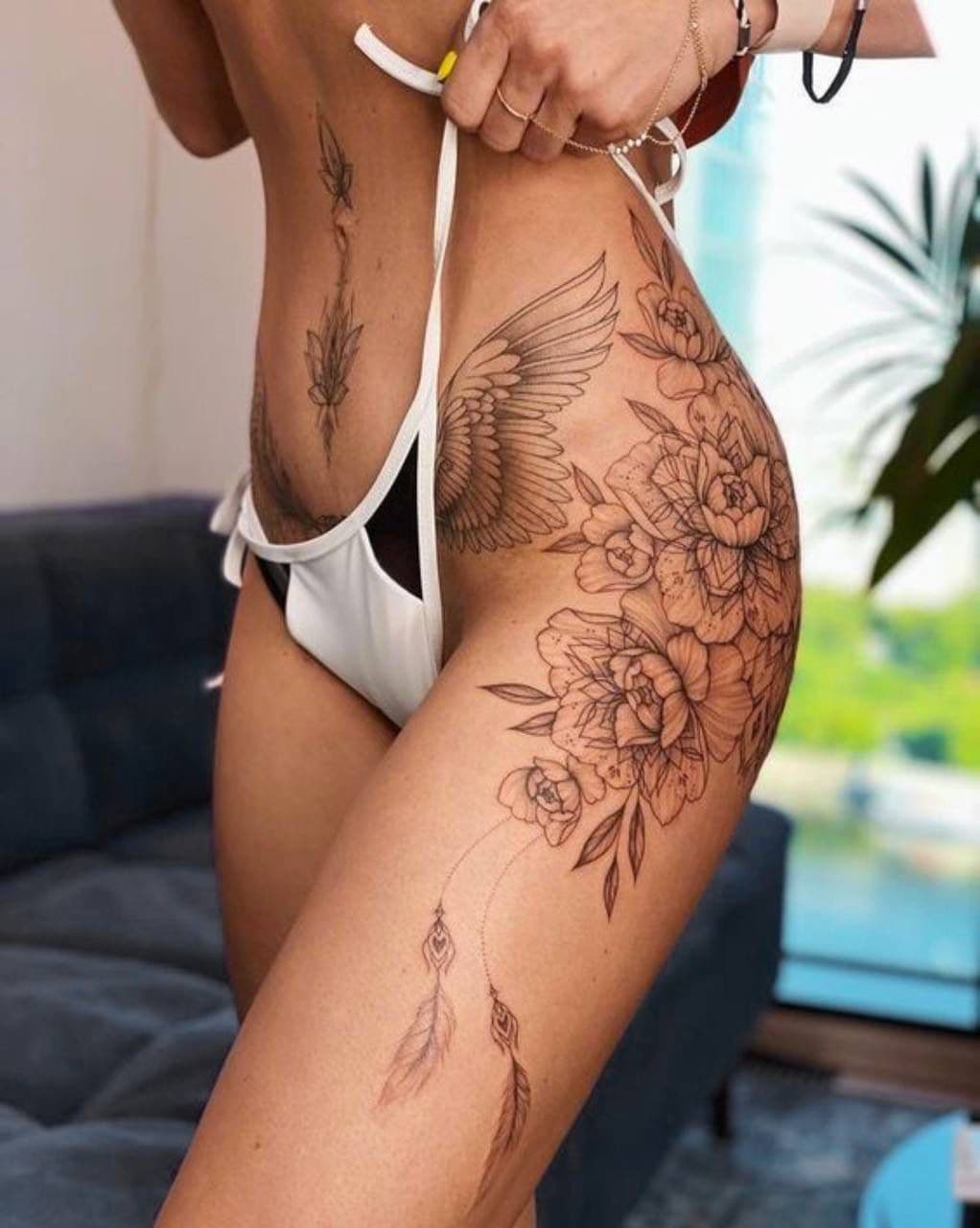 Fineline Tattoo – florales Hüft- und Oberschenkel-Ornament mit Flügel-Detail – Blood Diamond Tattoo Ink.